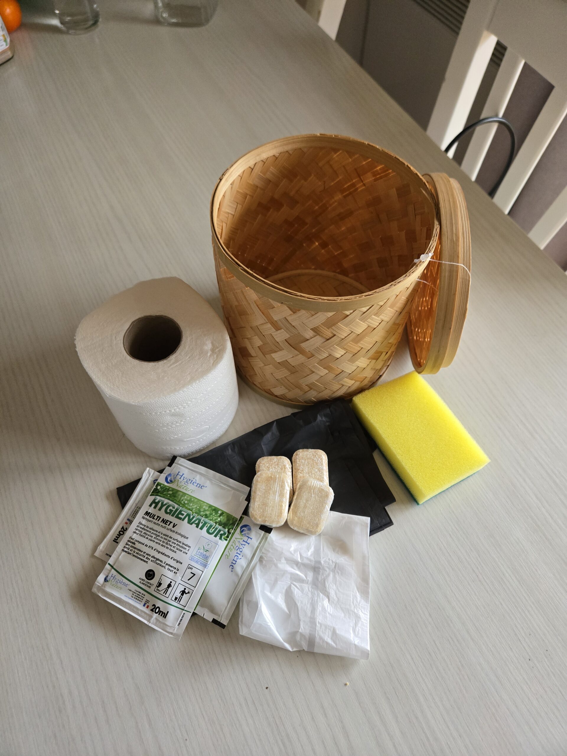 Un pot en bambou regroupant vos essentiels pour bien commencer le séjour : papier toilette, pastille lave‑vaisselle, produit d’entretien, éponge et sac‑poubelle.
